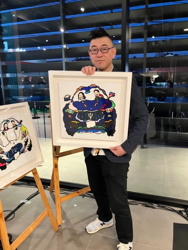 自身の作品を抱えて笑顔を見せる乗り物絵師の轟友宏さん