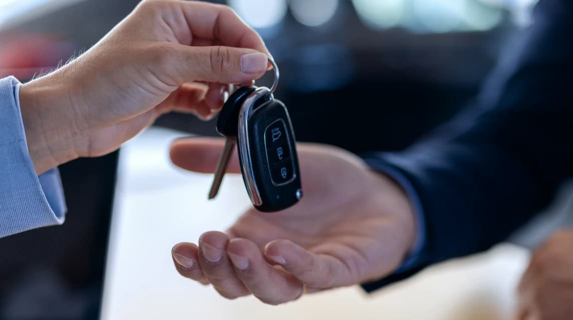 大切な外車を売却しスマートキーを手渡す買取成約の瞬間