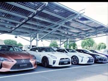 屋外の屋根付き展示場に整然と並べられたSUVなどの人気の中古車